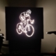 Nahaufnahme eines Eingeschalteten Lichtschildes als Fahrradaufhängung mit leuchtendem Fahrradfahrer